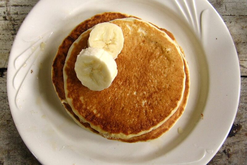 Stack of pancakes with butter and maple syrup