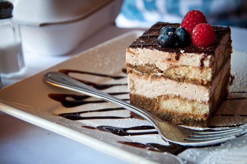 Slice of tiramisu dusted with cocoa powder on a plate