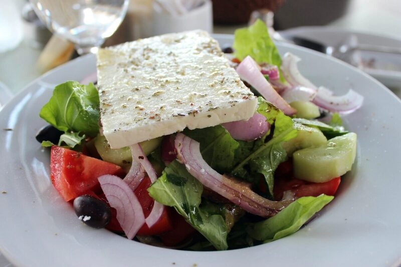Greek salad with tomato, cucumber, olives, and a slab of feta