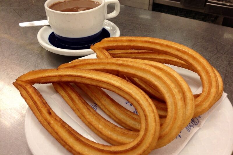 Small cup of thick Spanish hot chocolate served with churros for dipping