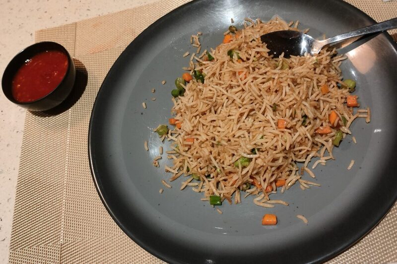 Wok of vegetable fried rice with scrambled egg and spring onion